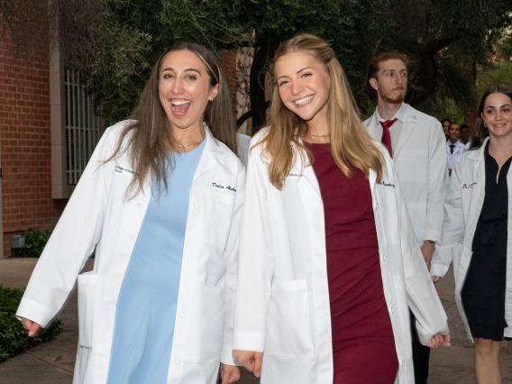 Dalia Alsbiei and Claire Rosenberger are all smiles as they leave Centennial Hall after the UArizona College of Medicine – Tucson Class of 2026 white coat ceremony.