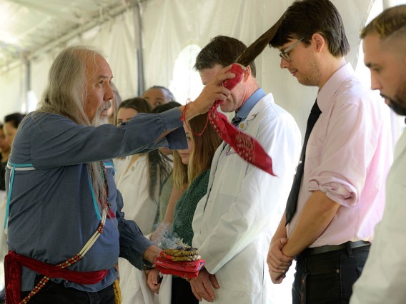 Carlos Gonzales, MD, blesses James V. Proffitt, PhD, an assistant professor of cellular and molecular medicine, with the smoke from sacred herbs and an eagle feather wand during the annual College of Medicine – Tucson Tree Blessing Ceremony.