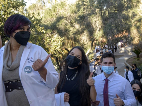 Serena Scott, MD, (left) and students Julia Alvarenga Fagundes Couto and Mark Bigbey wait in line before the class of 2024 white coat ceremony begins at UArizona Student Union Main Ballroom.