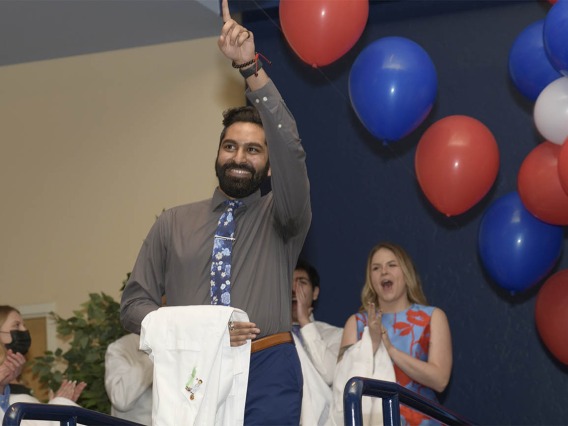 Mihir Shah celebrates as he walks onto the stage during the UArizona College of Medicine – Tucson’s class of 2024 white coat ceremony. 