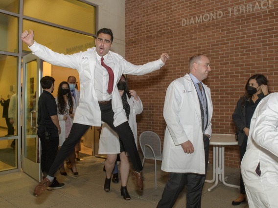 Even gravity can’t hold back the excitement David Ahmadian feels as he and his fellow class of 2024 College of Medicine – Tucson students emerge from their twice-postponed white coat ceremony in late February.  