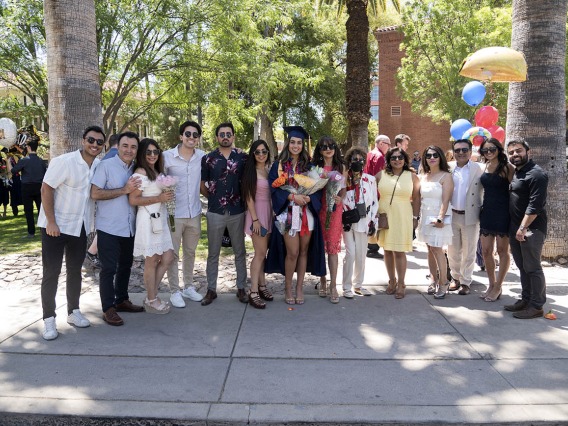 Bareen Rafiq poses for a photo with her family outside Centennial Hall after being awarded a Bachelor of Science in Nursing at the UArizona College of Nursing 2022 spring convocation.