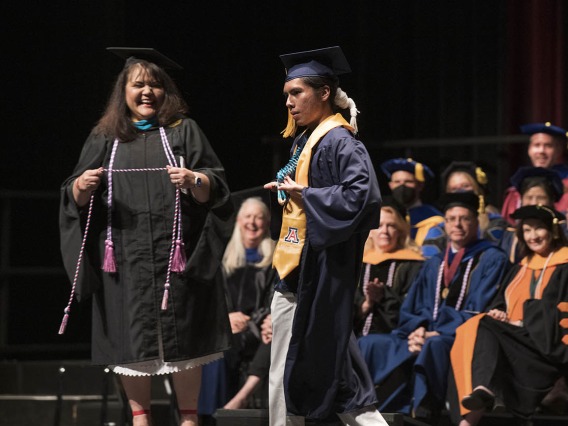 Linda Perez, MHA, RN, prepares to give a cord to Joshua Billy during the UArizona College of Nursing 2022 spring convocation at Centennial Hall.