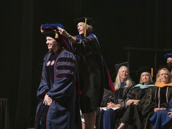 Stacy Al-Saleh, PhD, is hooded by Kathie Insel, PhD, RN, for earning her Doctor of Philosophy in Nursing during the UArizona College of Nursing 2022 spring convocation at Centennial Hall. 