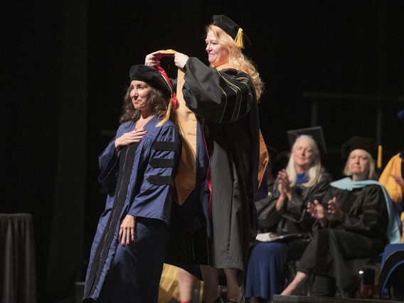 Elizabeth Partida, DNP, is hooded by Kristie Hoch, DNP, CRNA, MS, RRT, for earning her Doctor of Nursing Practice during the UArizona College of Nursing 2022 spring convocation at Centennial Hall.
