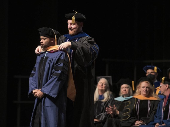 James Gibson, DNP, is hooded by Charles “Reggie” Elam, PhD, DNAP, CRNA, for earning his Doctor of Nursing Practice during the UArizona College of Nursing 2022 spring convocation at Centennial Hall. 