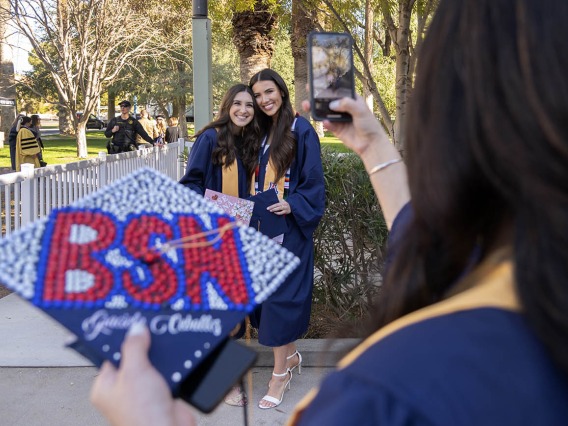 Graciela Ceballos takes a photo of her friends, Gianna Casella and Talia Acereto before the College of Nursing convocation at Centennial Hall.
