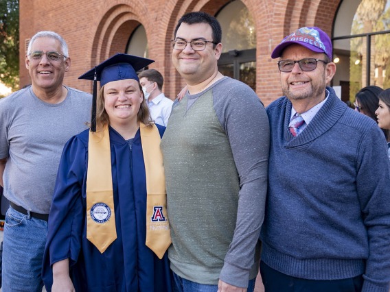 College of Nursing student Elizabeth Dueñes poses for a family photo with her father-in-law, Steve Dueñes (left), her husband Michael Dueñes (center) and her father Jim King at the fall convocation at Centennial Hall.
