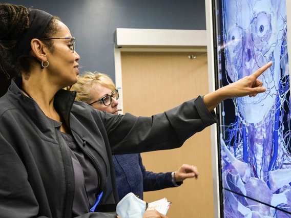 A UArizona Colllege of Nursing professor reviews the anatomage table with a simulation educator.