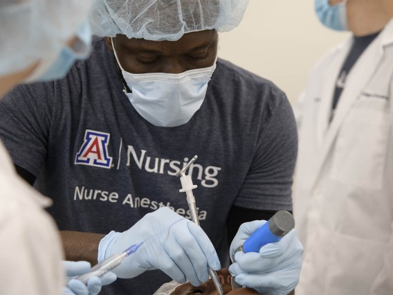 CRNA student Olu Bello, RN, intubates a manikin during a crisis management clinical skills intensive simulation in the Arizona Simulation Technology and Education Center. 