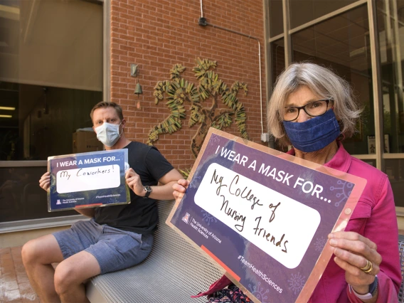 Motivated to protect others. From left: Will Holst, director of marketing and communications, Ida M. “Ki” Moore, PhD, RN, FAAN, dean of the College of Nursing.