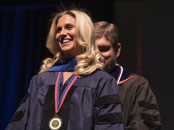 Kayla Frost, PhD, is hooded by Nathan Cherrington, PhD, ATS, for earning a Doctor of Philosophy degree in pharmacology and toxicology during the R. Ken Coit College of Pharmacy 2022 spring convocation at Centennial Hall.
