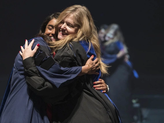 Srujitha Marupuru, PhD, hugs her advisor Terri Warholak, PhD, RPh, after being hooded for earning her Doctor of Philosophy degree in pharmacology and toxicology during the R. Ken Coit College of Pharmacy 2022 spring convocation at Centennial Hall.