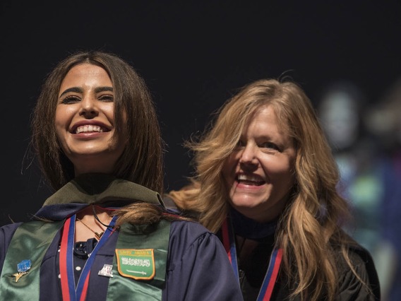 Nouf Bin Awad, MSPS, smiles after being hooded by Terri Warholak, PhD, RPh, for earning her Master of Science in Pharmaceutical Sciences during the R. Ken Coit College of Pharmacy 2022 spring convocation at Centennial Hall.