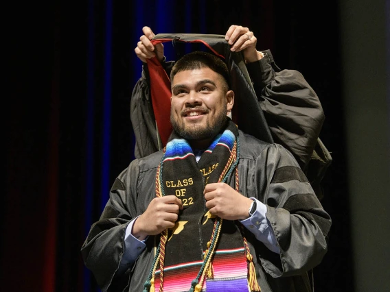 Jonathan Corrales, PharmD, is hooded by Ashley Campbell, PharmD, BCPS, for earning his Doctor of Pharmacy during the R. Ken Coit College of Pharmacy 2022 spring convocation at Centennial Hall.