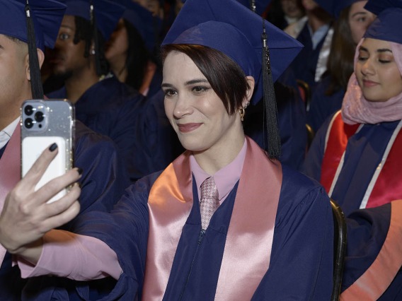 Iris Elizabeth Lococo, who graduated with a Master of Public Health degree, snaps a photo during the Mel and Enid Zuckerman College of Public Health fall convocation.
