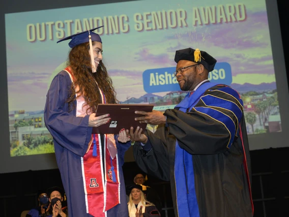 Aisha Fregoso is presented with the Outstanding Senior Award by John Ehiri, PhD, MPH, MSc, during the Mel and Enid Zuckerman College of Public Health fall convocation. 