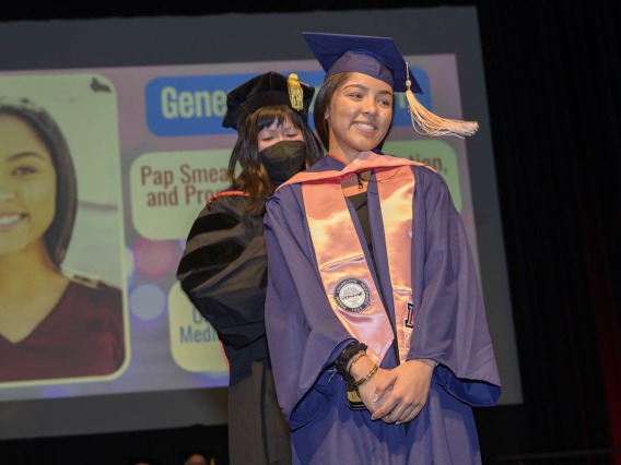 Master of Public Health graduate Geneva Frank is hooded by associate professor Nicole Yuan, PhD, MPH, during the Mel and Enid Zuckerman College of Public Health fall convocation.