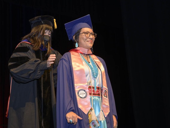 Master of Public Health graduate Breanna Lameman is hooded by associate professor Nicole Yuan, PhD, MPH, during the Mel and Enid Zuckerman College of Public Health fall convocation. 