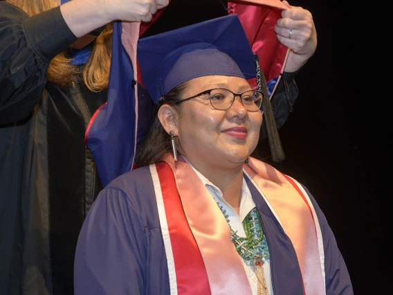 Lucynda Gorman Dahozy prepares to be hooded as a Master of Public Health graduate during the Mel and Enid Zuckerman College of Public Health fall convocation.