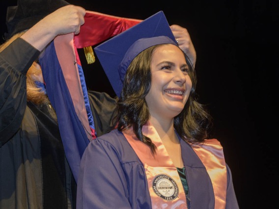 Belen Alejandra Mejia happily anticipates being hooded as a Master of Public Health graduate during the Mel and Enid Zuckerman College of Public Health fall convocation.