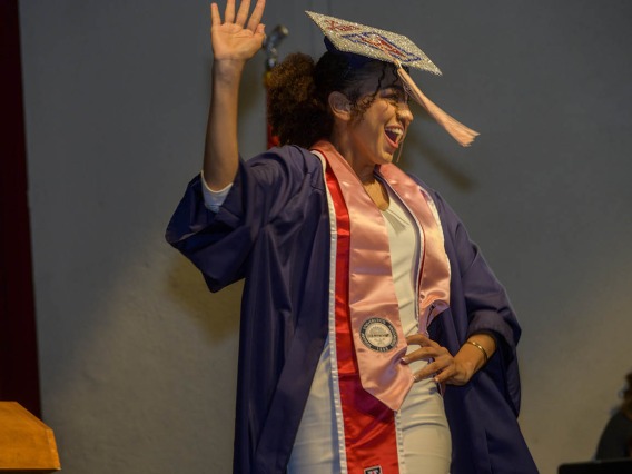 Kayla Allender hams it up for the audience as she walks onto the stage at Centennial Hall to receive her diploma during the Mel and Enid Zuckerman College of Public Health fall convocation. 