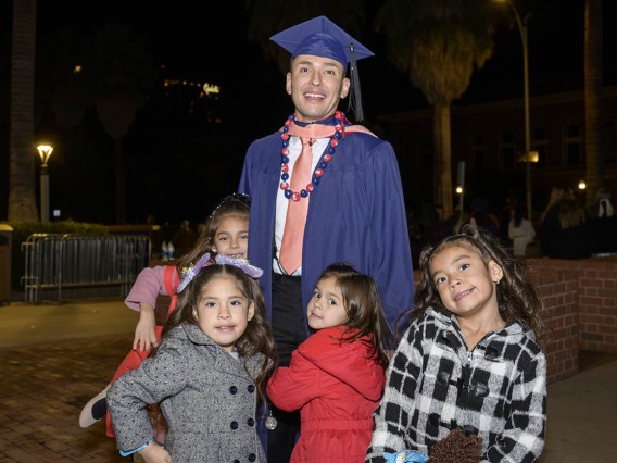 Master of Public Health graduate Eduardo Estrada is congratulated by his daughters and nieces the Mel and Enid Zuckerman College of Public Health fall convocation.