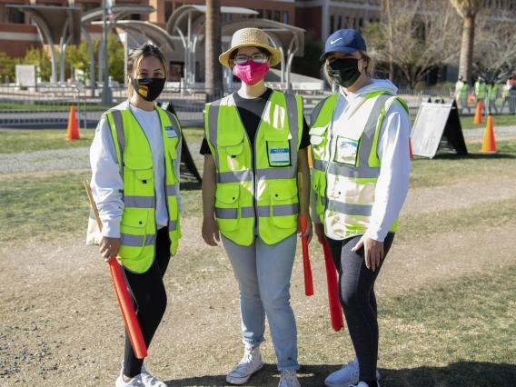 UArizona Health Sciences students Rebecca Lynn Amador, Ashley Casarez and Dariana Fimbres volunteer as traffic directors at the UArizona Point of Distribution in Pima County.