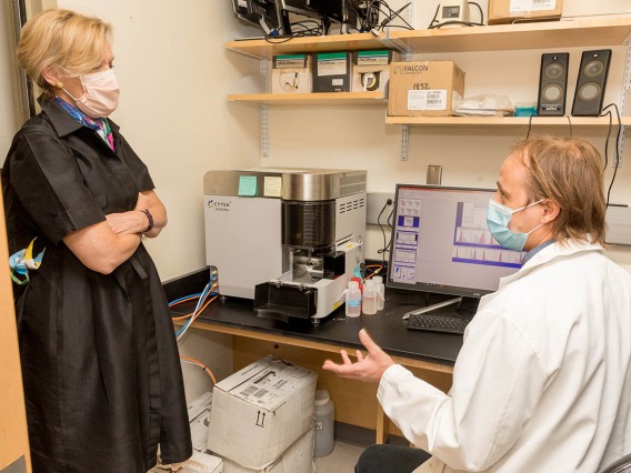 Deborah Birx, MD, coordinator of the White House Coronavirus Task Force, talks with a scientist during a recent tour of laboratories. The tour focused on the labs testing antibody and antigen samples collected from students and employees.