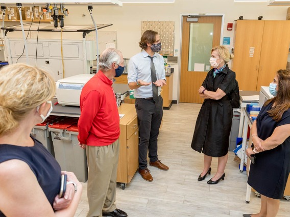 Deborah Birx, MD, coordinator of the White House Coronavirus Task Force, listens as Ryan Sprissler, PhD, staff scientist and manager of the UArizona Genetics Core, explains the antibody testing process. UArizona President Robert C. Robbins, MD, and others, joined Dr. Birx during her visit.