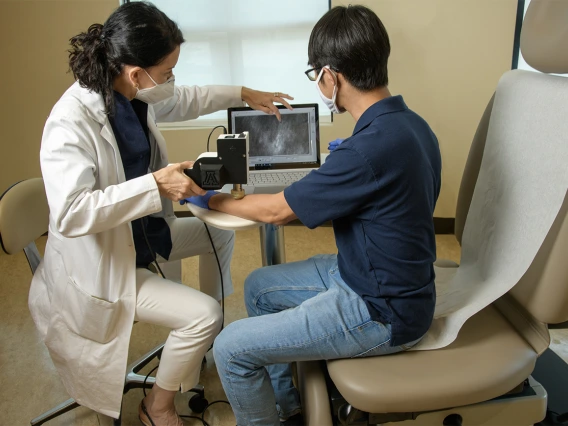 Drs. Curiel and Kang look at the image quality of the handheld skin cancer diagnostic microscope they are developing. The technology is meant to provide a less expensive, portable version of a machine that is presently cost-prohibitive for many medical facilities.