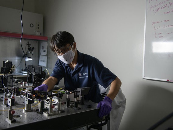 Dongkyun Kang, PhD, works to align the laser optics to increase the light power of a portable confocal microscope he is  developing with Clara Curiel-Lewandrowski, MD.