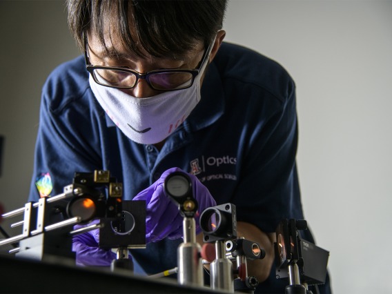 Dongkyun Kang, PhD, works to align the laser optics to increase the light power of a portable confocal microscope he is  developing with Clara Curiel-Lewandrowski, MD.
