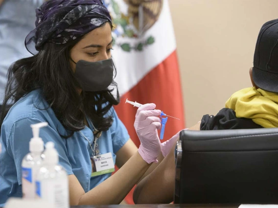 College of Medicine – Tucson senior medical student Maya Sarihan gives a COVID-19 vaccination to an agricultural laborer April 23 during a MOVE UP clinic at the Mexican Consulate in Douglas, Arizona.