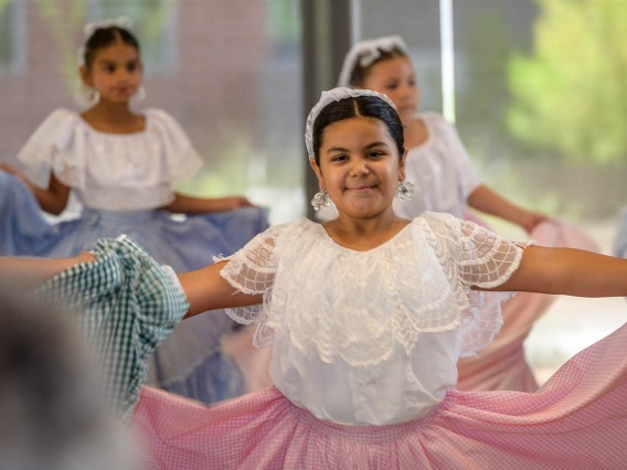 Gabby Mendez smiles at her parents as she dances with the Ballet Folklorico Tapatio group during the Feast for Your Brain community event. 
