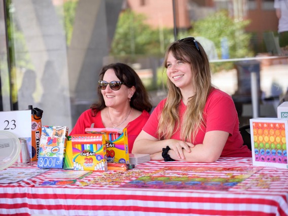(From left) Sabrina Plattner, MEd, and Lindsay Bingham, MPH, CHES, both senior health educators in the Mel and Enid Zuckerman College of Public Health, volunteer at an activity table during the inaugural Feast for Your Brain community event on Sept. 10.