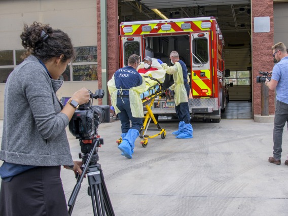 University of Arizona Health Sciences’ Viola Watson (left) and Erich Healy (right) wield cameras as the Tucson Fire Department, in partnership with the College of Public Health, produces a training video to help first responders prevent disease transmission.