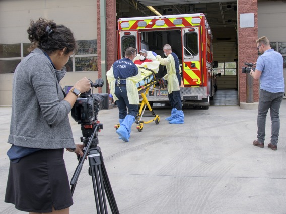 University of Arizona Health Sciences’ Viola Watson and Erich Healy document the loading of a patient into ambulance. Healy works for the Mel and Enid Zuckerman College of Public Health and the Western Regional Public Health Training Center.