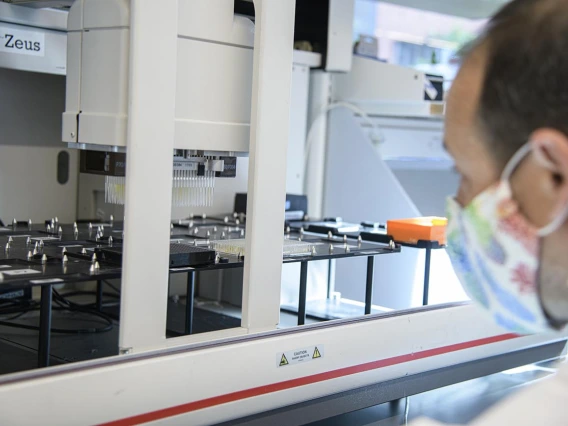 Matthew Kaplan, manager for University of Arizona Functional Genomics Core, evaluates the Biomek robot prior to performing antibody testing.