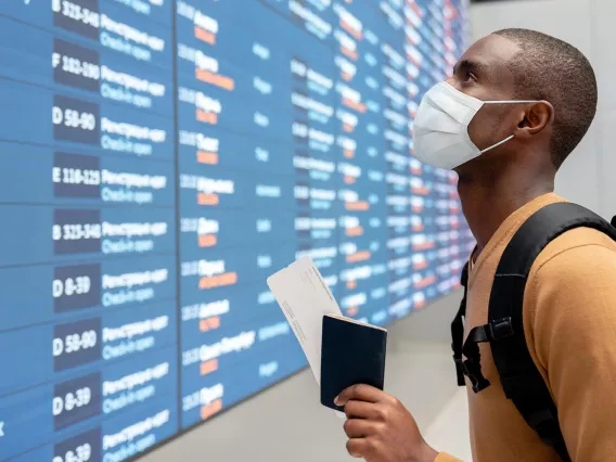 If you must fly, make sure to mask up in the airport and on the plane.