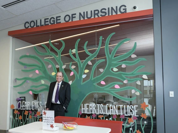 UArizona Health Sciences Senior Vice President Michael D. Dake, MD, stands at the entrance of the College of Nursing’s renovated third-floor facility in Gilbert, Arizona.
