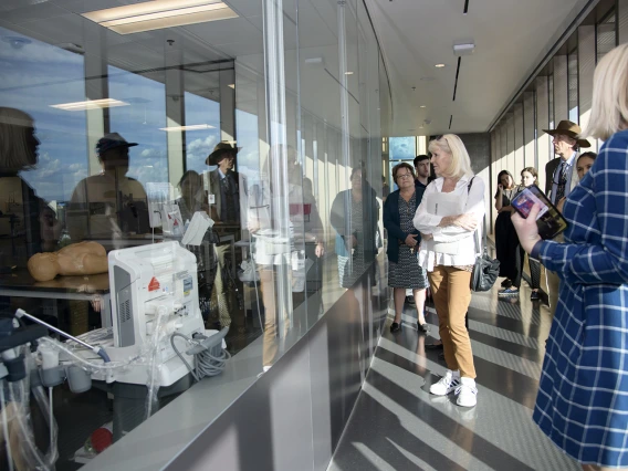 Faculty peer into the “aquarium” windows of the Arizona Simulation Technology and Education Center, or ASTEC.