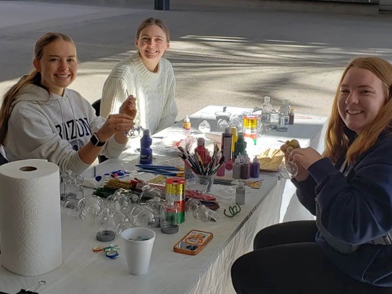 The R. Ken Coit College of Pharmacy Office of Student Services hosted an end of semester holiday party where (from left clockwise) Alex McDaniel, Reagan Blanchard and Jenna Harris, all pharmaceutical sciences undergraduate students, paint ornaments and decorate holiday cookies. 