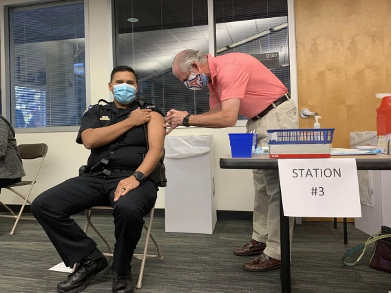 University of Arizona President Robert C. Robbins, MD, administers the vaccine to a University of Arizona Police officer.