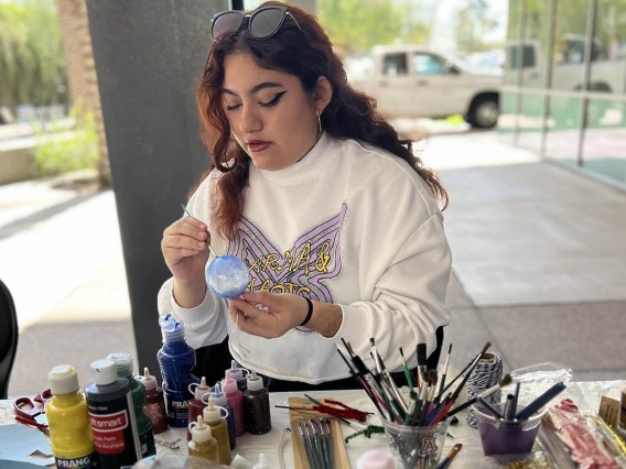 Aryanna Lozano, a pharmaceutical science undergraduate student in the R. Ken Coit College of Pharmacy, paints an ornament at an end of semester holiday party hosted by the College of Pharmacy Office of Student Services.