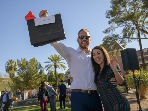 Austen and Darian Thompson lift the bag that will tell them where they will be for the next four years before the 9 a.m. start to matching during the UArizona College of Medicine – Tucson 2022 Match Day event.