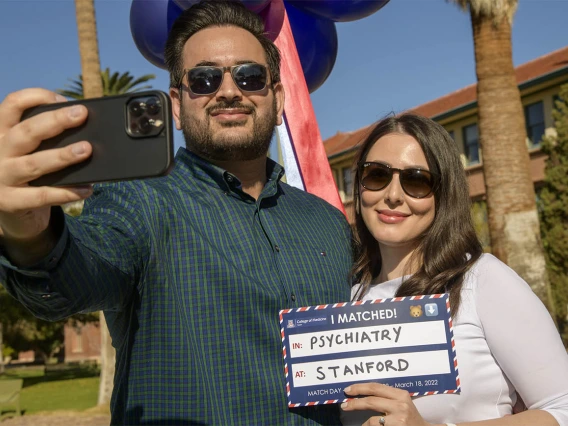 Mohammad Mojadidi and his fiancé Madina Jahed snap a selfie as Jahed shows her match to Stanford during the UArizona College of Medicine – Tucson 2022 Match Day event.