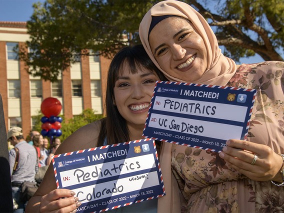 Paulina Ramos (left) and Tesneem Tamimi display their signs showing where they matched during the UArizona College of Medicine – Tucson 2022 Match Day event.