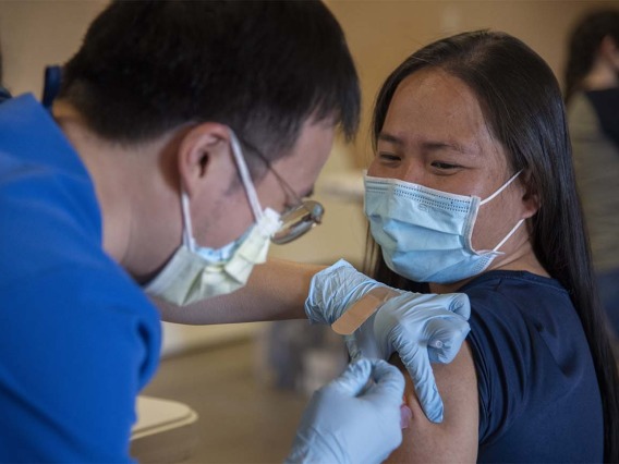 Alvin Wong, DO, a clinical associate professor with the College of Medicine – Phoenix, administers a COVID-19 vaccine to a patient at the community center in Aguila, Arizona, a rural agricultural community west of Phoenix in Maricopa County. 