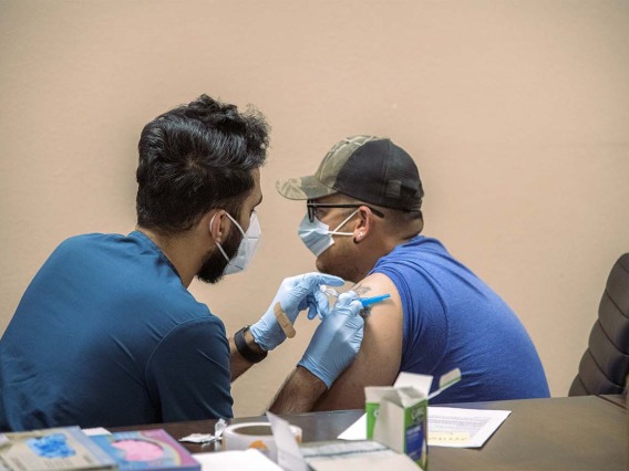 College of Medicine – Tucson senior Abdullah Aleem gives farm work supervisor Rubén Sosa a COVID-19 vaccine shot. The goal of MOVE UP is to promote more inclusive participation of rural and underrepresented groups in getting the vaccine among hard-to-reach populations in partnership with the UArizona Health Sciences, state and county health departments and other local partnerships.